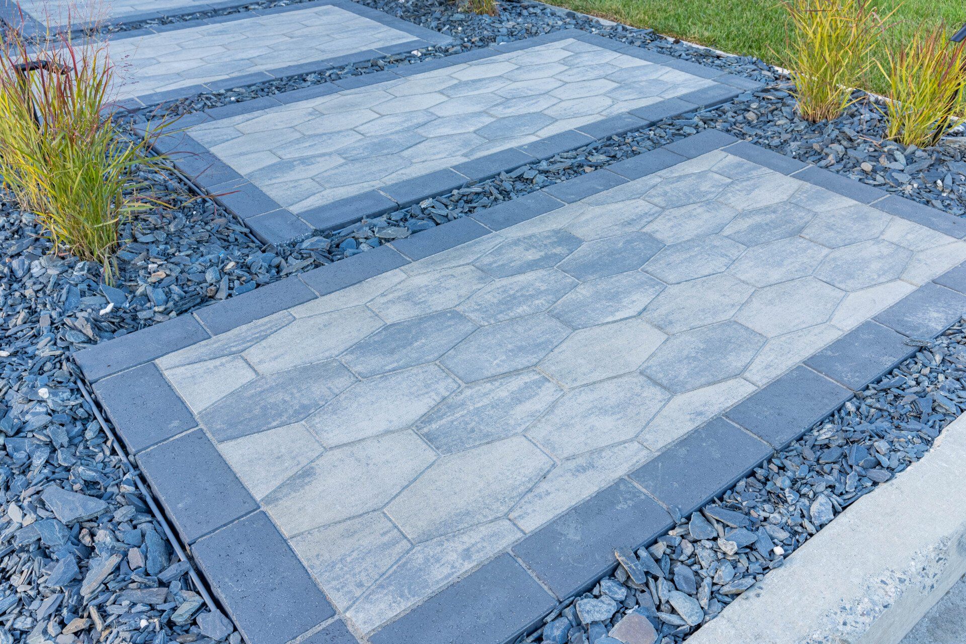 Une allée faite de briques et de gravier dans un jardin.