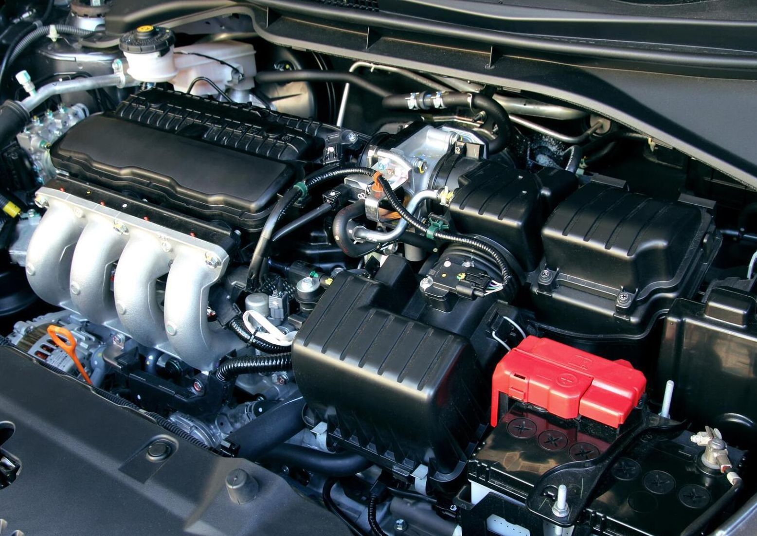 A close up of a car engine with the hood open