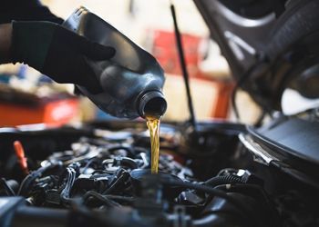 a person is grinding a piece of metal on a car .