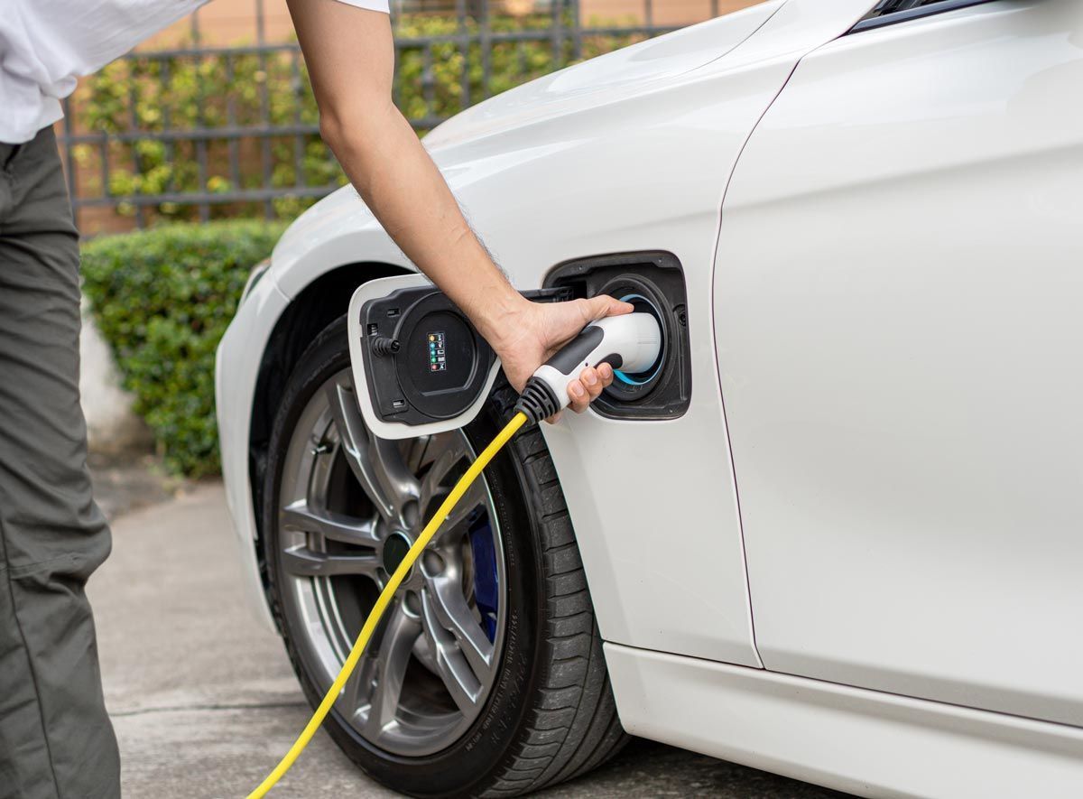 A person is charging an electric car with a charger.