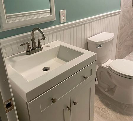 A bathroom with a sink , toilet and mirror.