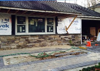 A house is being remodeled with a stone facade.