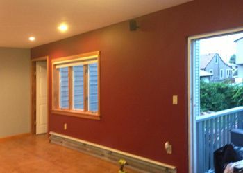 A living room with red walls and a window.