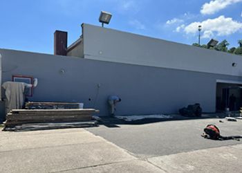 A man is working on the side of a building.