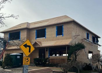 A house under construction with a yellow sign that says 15 mph.