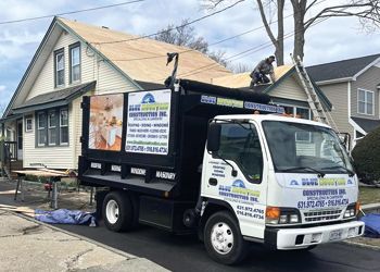 A dump truck is parked in front of a house.