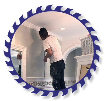 A man painting a wall with a blue circular saw blade