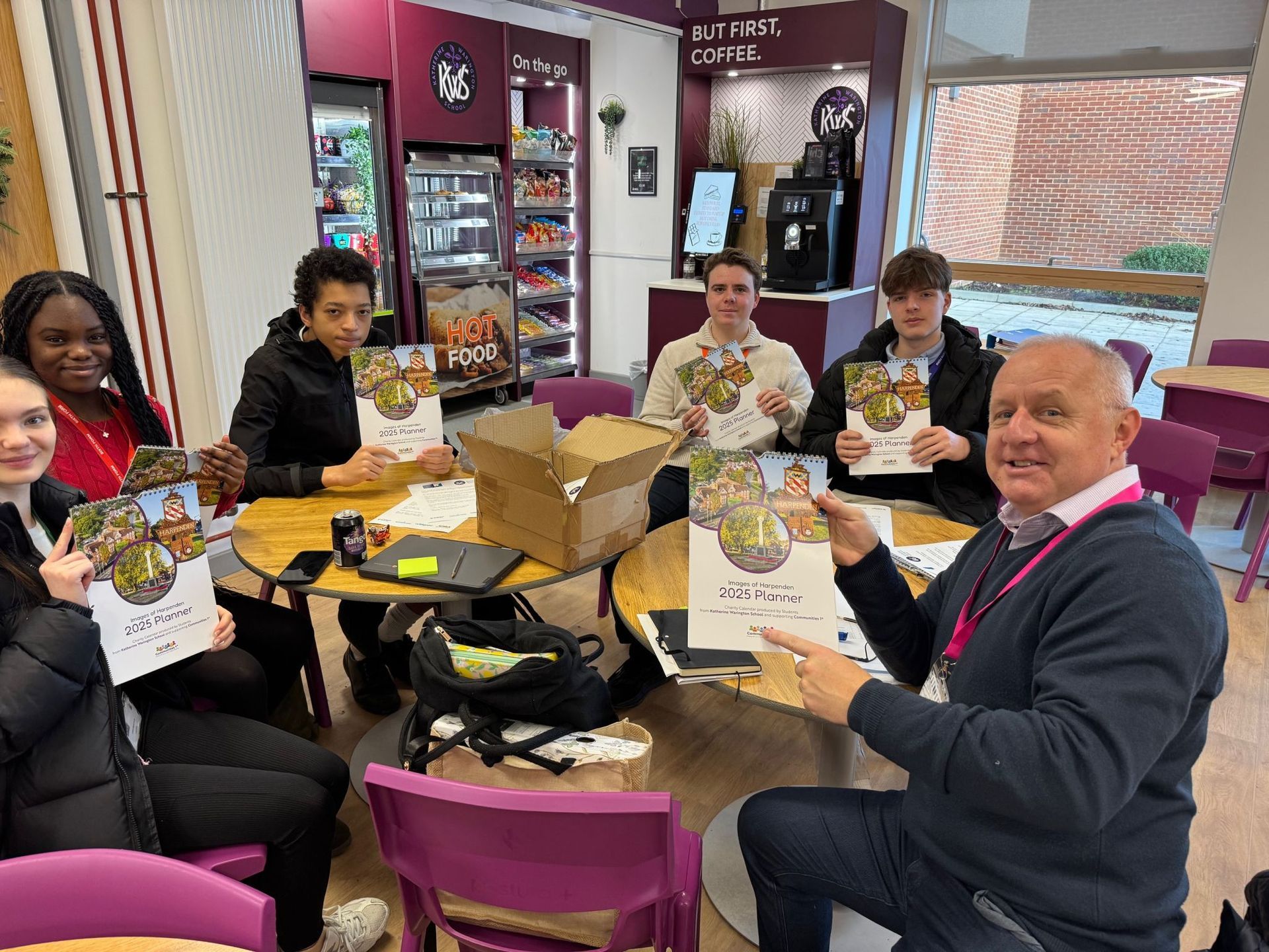 A group of people are sitting around a table holding flyers.