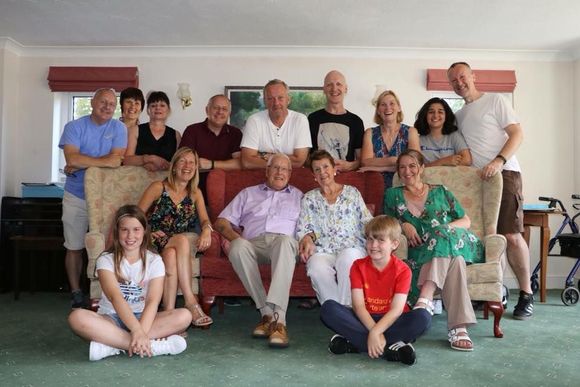 Peter's family are posing for a picture in a living room.