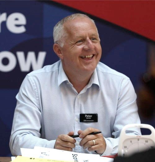 Peter Barker is wearing a name tag that says Ambassador