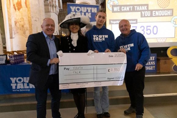 Peter Barker is presenting a cheque to Youth Talk