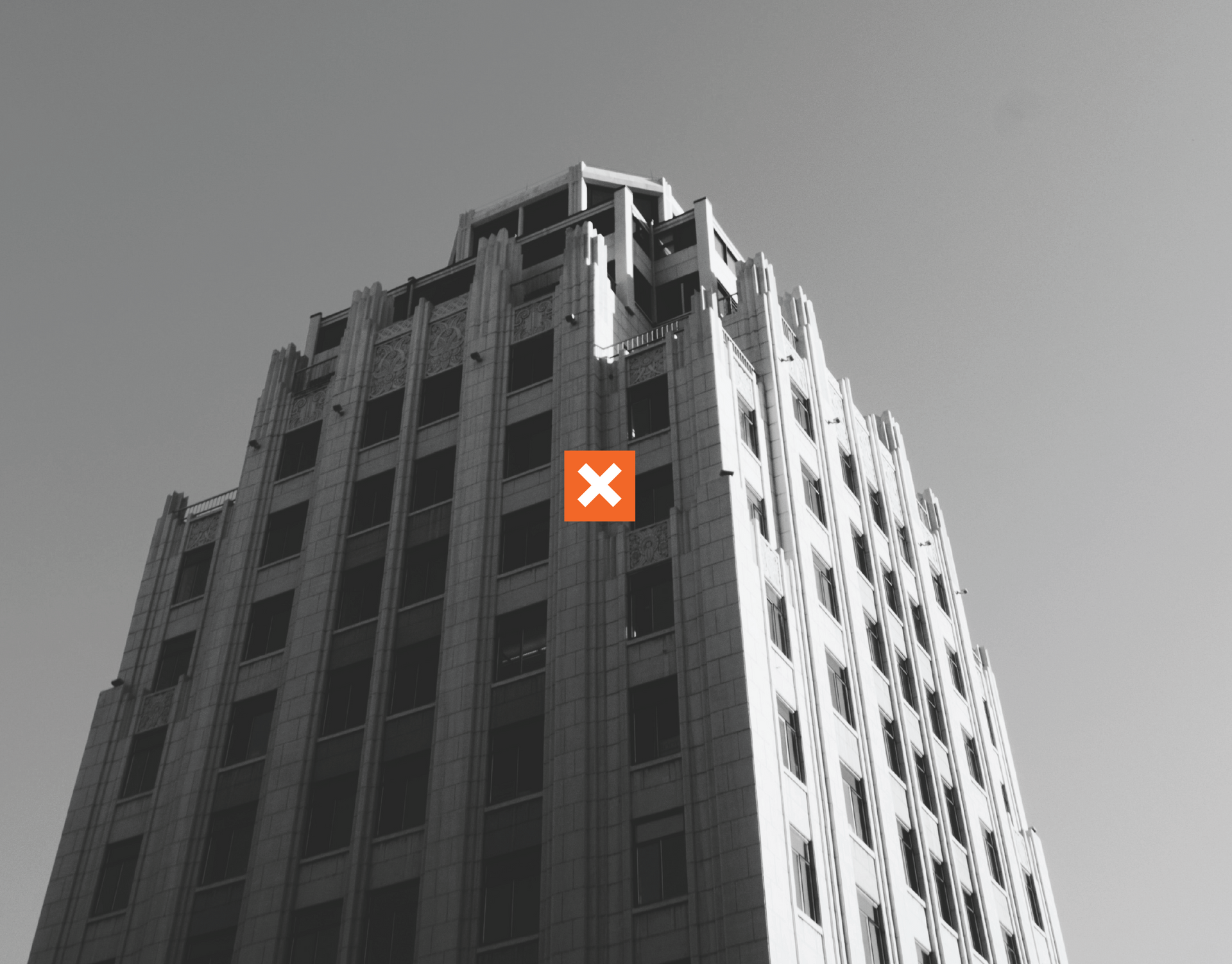 A black and white photo of a tall building with an x on it.