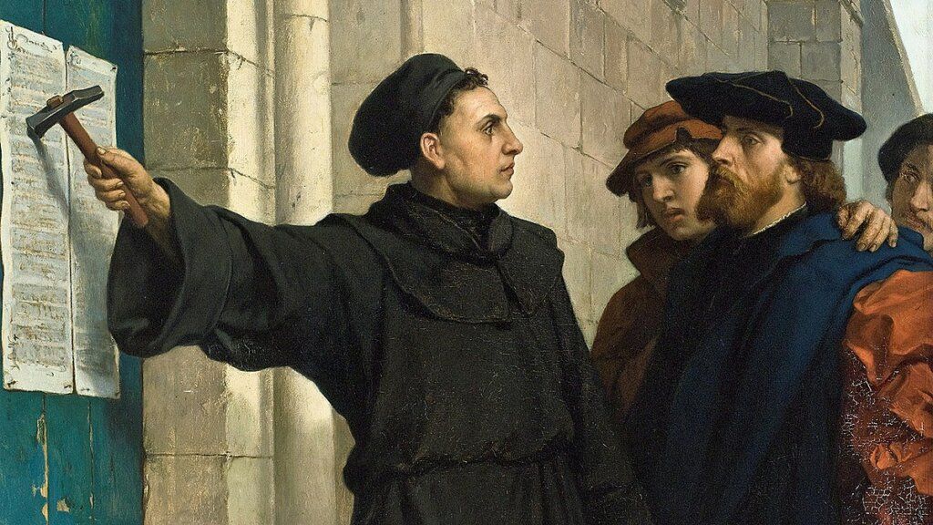 Martin Luther nailing his Ninety-Five Theses to a church door. Men watch in somber tones.