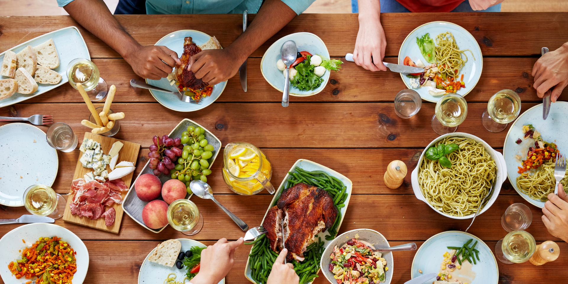 Plates of food being served at a restaurant, hand of server visible. Yellow and blue color grade.