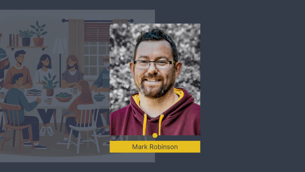 Man smiling, wearing glasses and a maroon hoodie. Illustration of people at a table.
