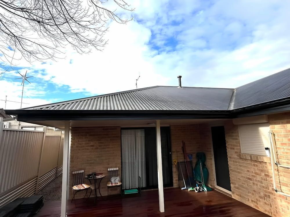 Backyard Patio With Brick Walls and Corrugated Roof — Primed Plumbing & Gasfitting in Lithgow, NSW