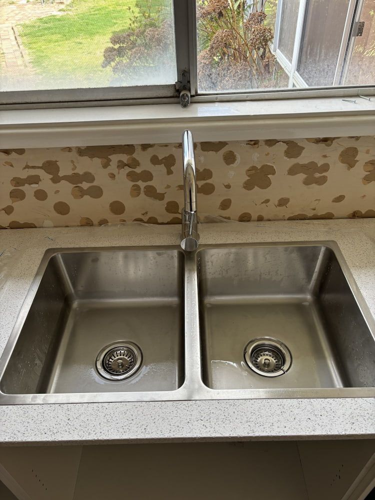 Stainless Steel Double Sink by Window and Tap Water — Primed Plumbing & Gasfitting in Eglinton, NSW