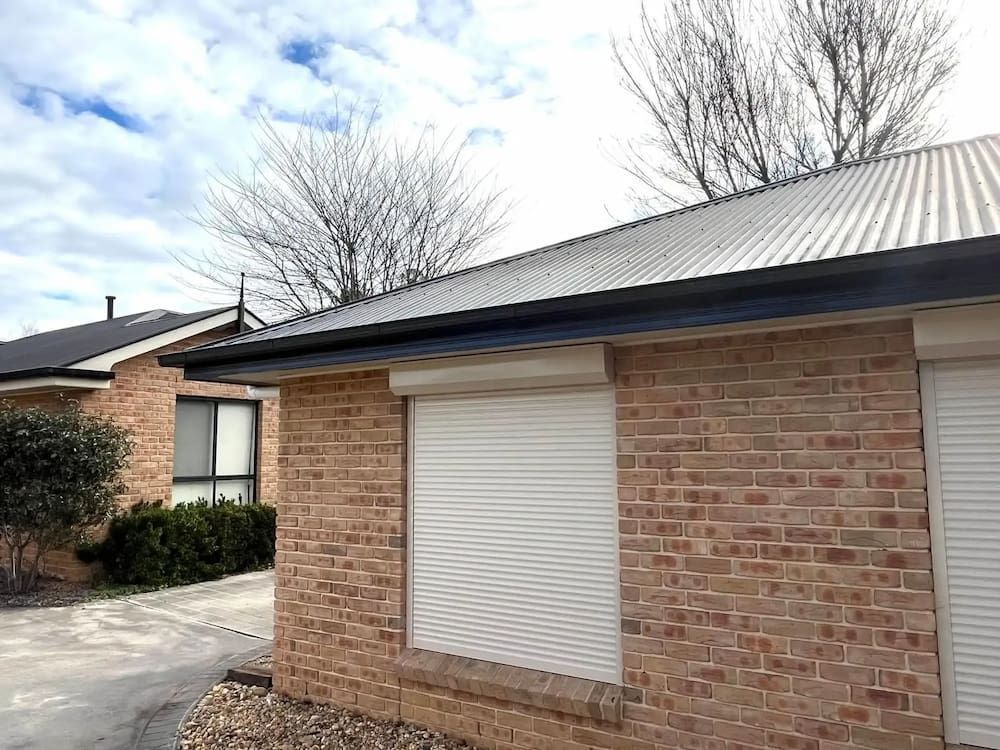 Brick Building With Closed White Shutters and Metal Roof — Primed Plumbing & Gasfitting in Eglinton, NSW