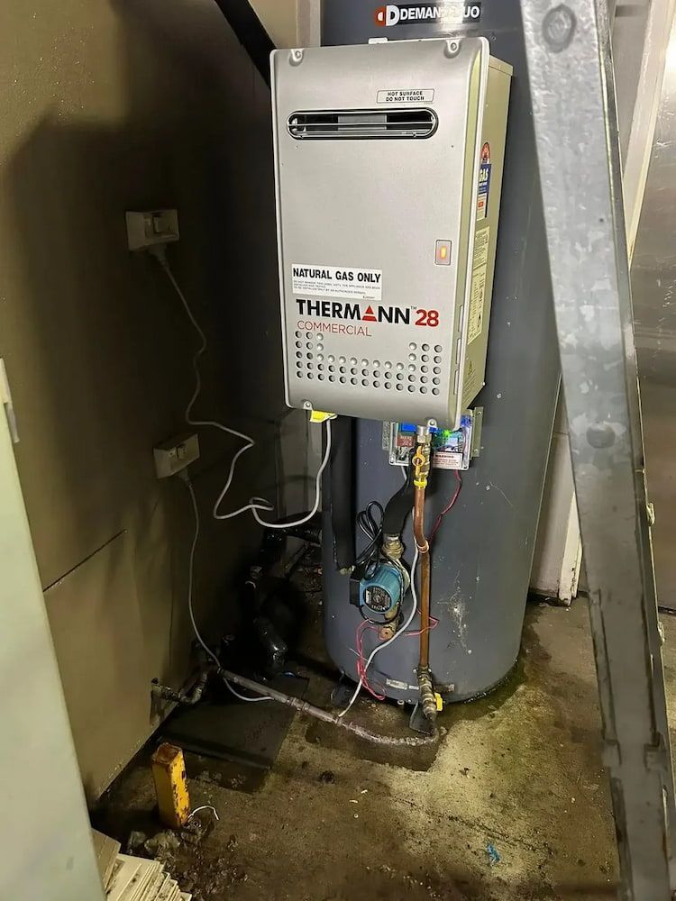 A Wall-mounted Thermann 28 Water Heater Next to a Water Tank — Primed Plumbing & Gasfitting in Orange, NSW