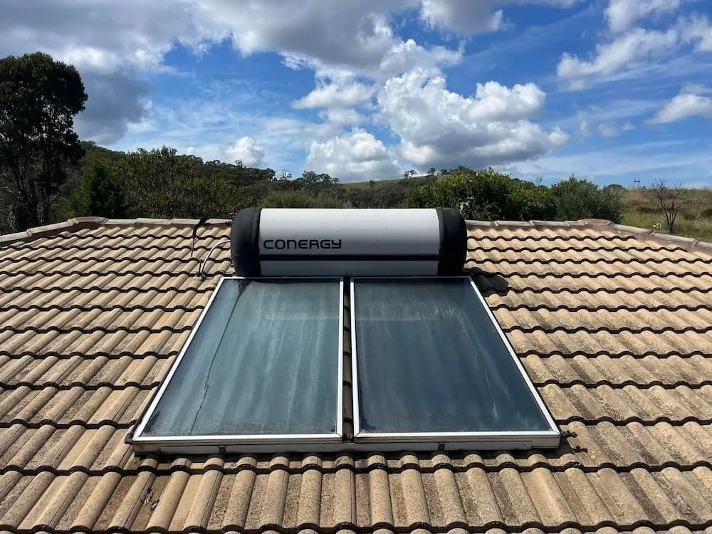 Solar Water Heater on a Tiled Roof Against a Blue Sky — Primed Plumbing & Gasfitting in Eglinton, NSW