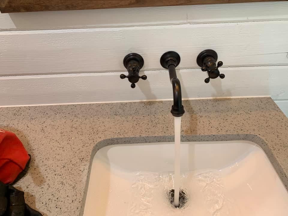 A bathroom sink with water running from the faucet.