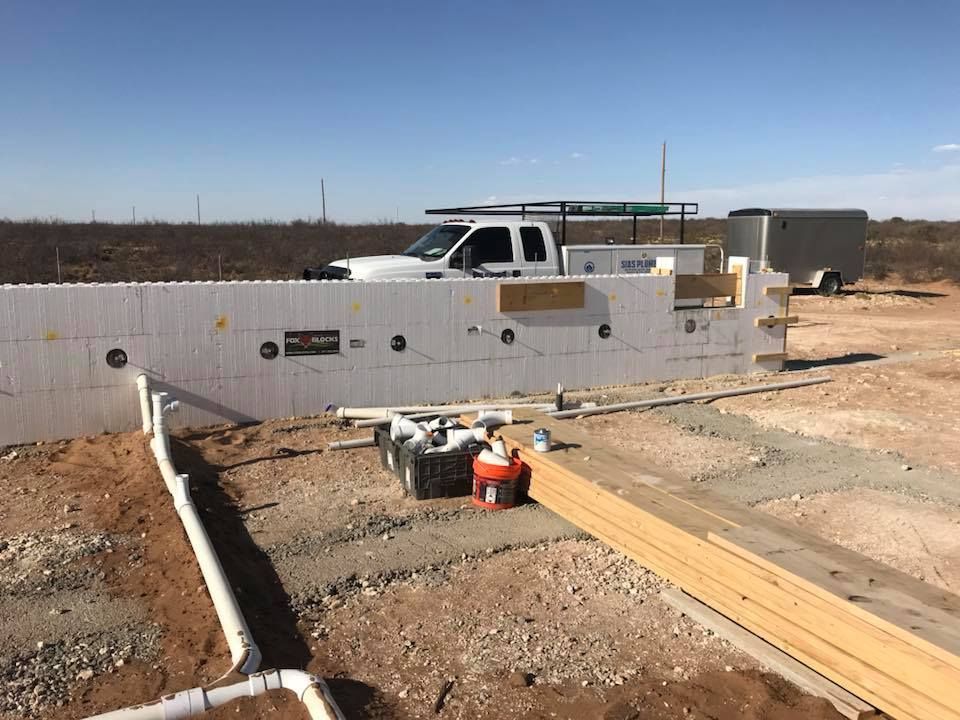 A white truck is parked on the side of a dirt road.