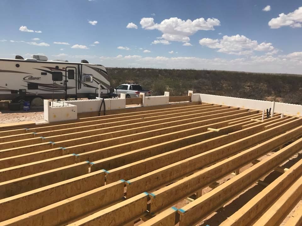 A wooden deck with a rv parked in the background