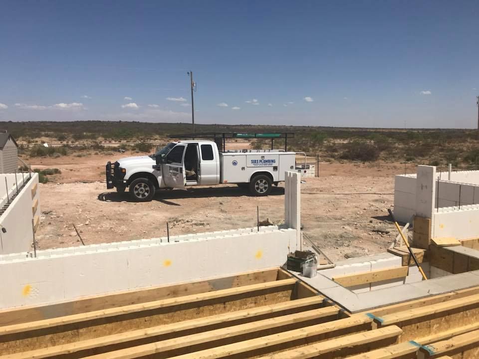 A white truck is parked in the middle of a construction site.