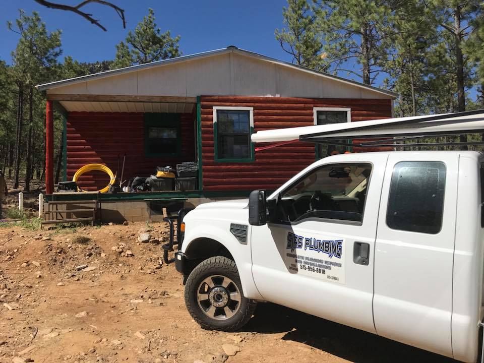 A white truck is parked in front of a house.