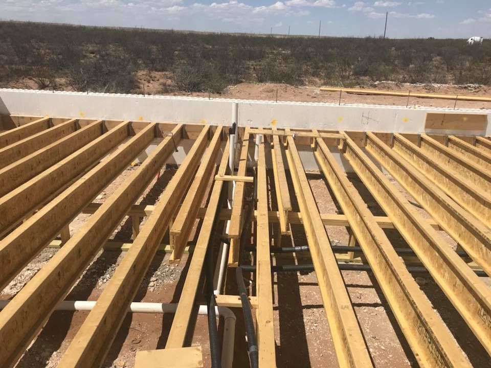 A row of wooden beams are sitting on top of each other on a construction site.