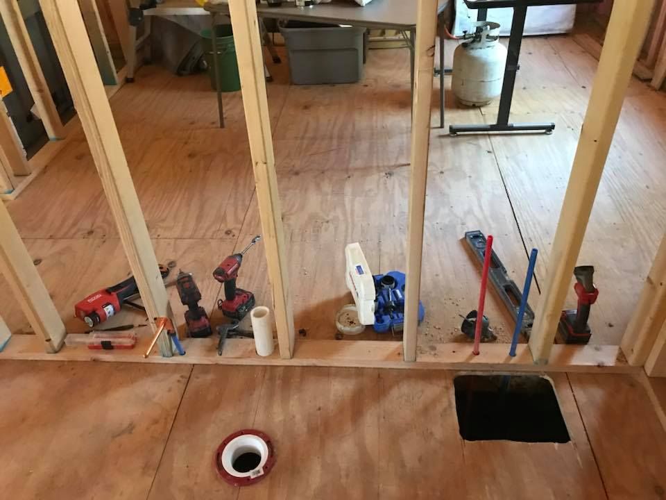 A bathroom under construction with a hole in the floor