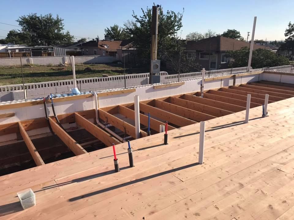 A wooden deck is being built on top of a house