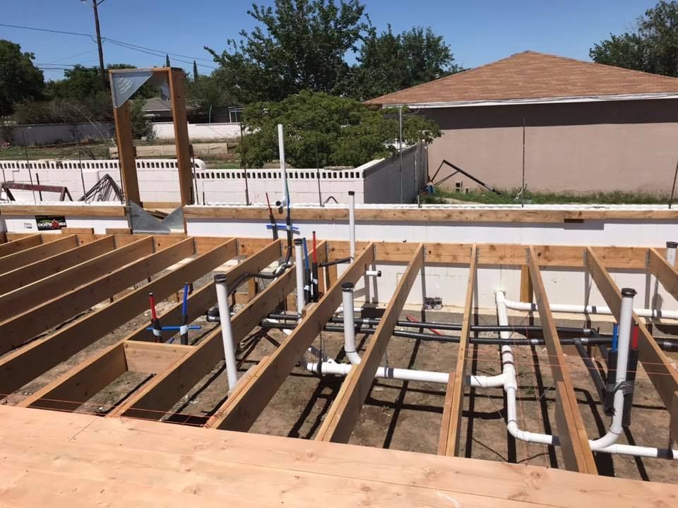 A house is being built with wooden beams and pipes.