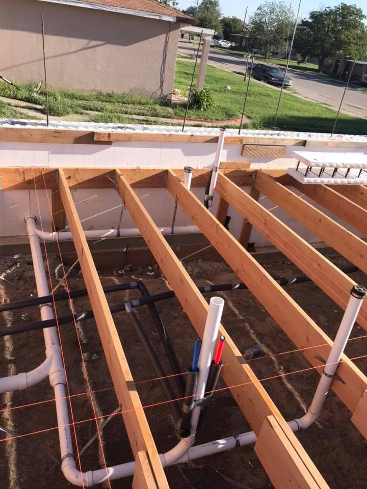 A wooden structure with a lot of pipes underneath it