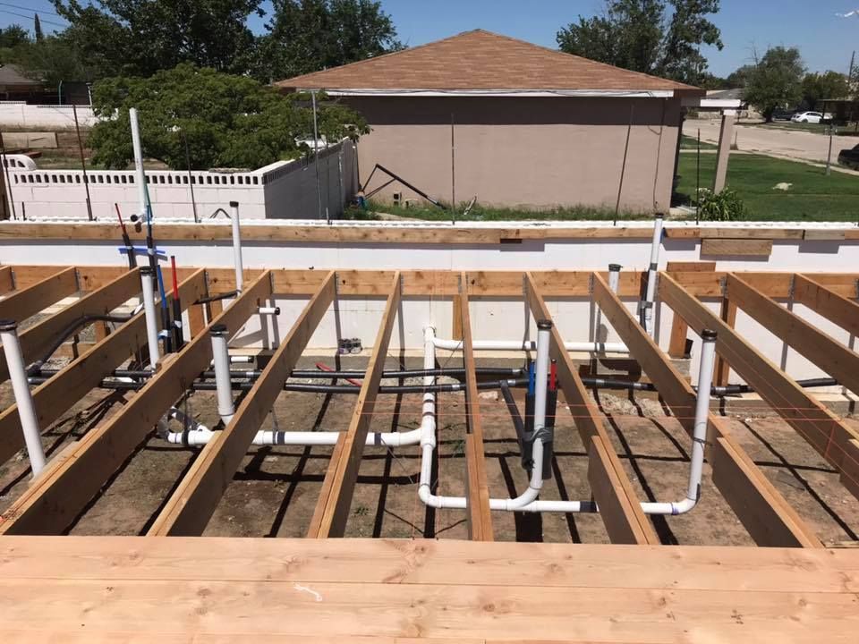 A house is being built with wooden beams and pipes
