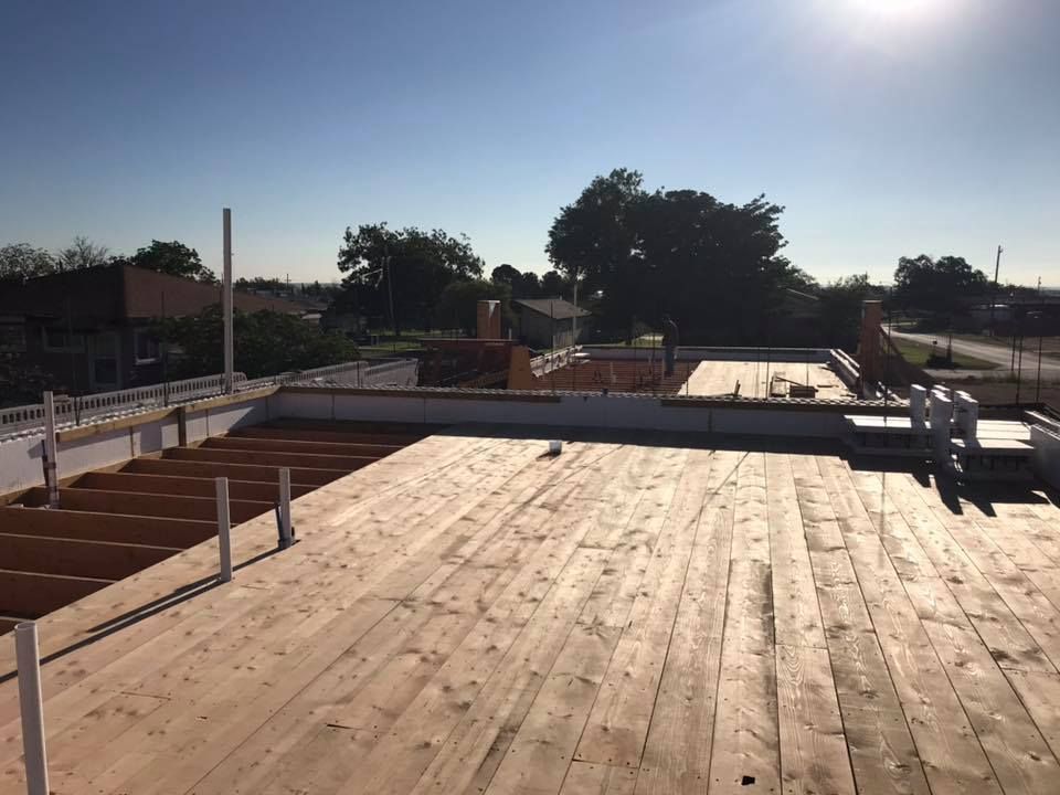 A wooden deck is being built on the roof of a building.