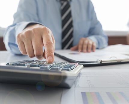 Accountant working on calculator — Accounting Services in Eugene, OR