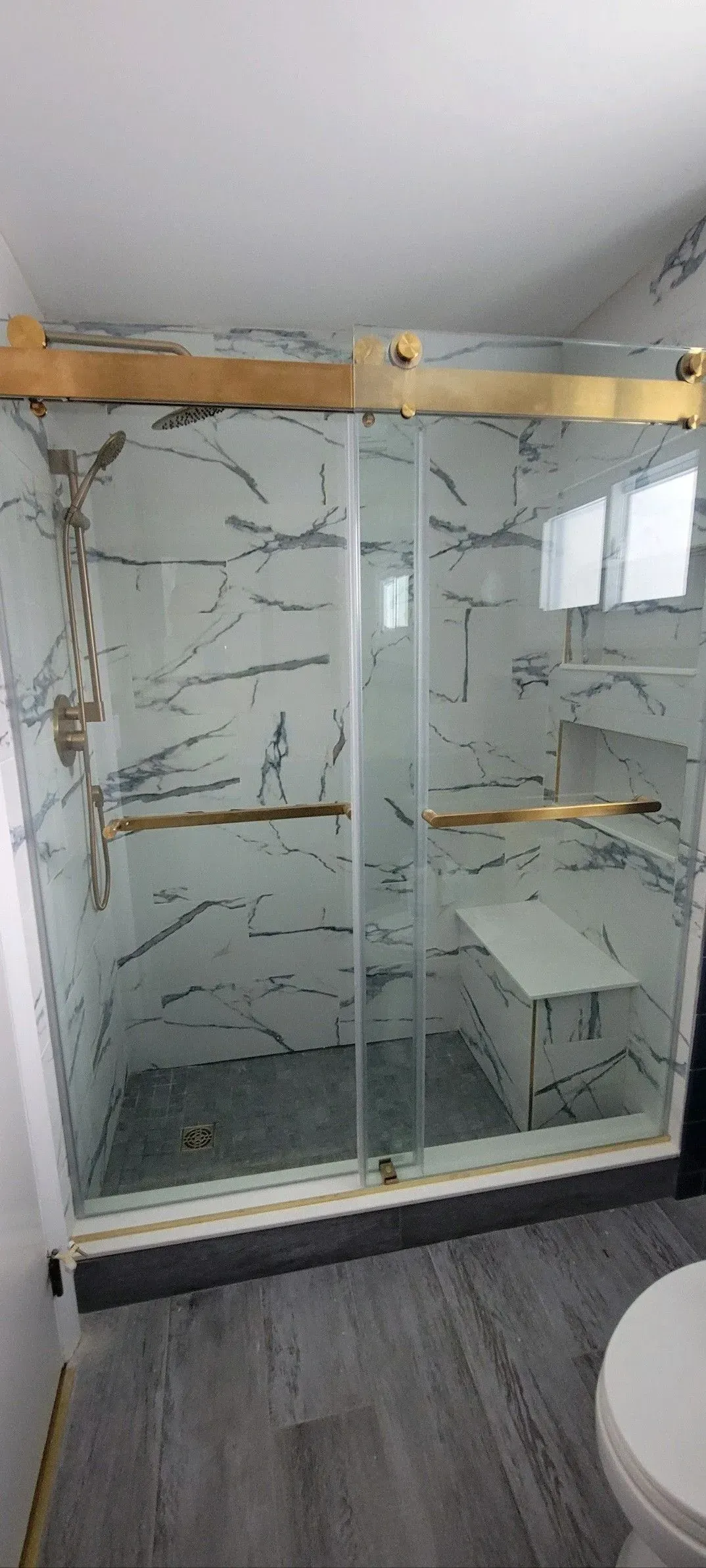 A bathroom with a sliding glass shower door and a toilet.