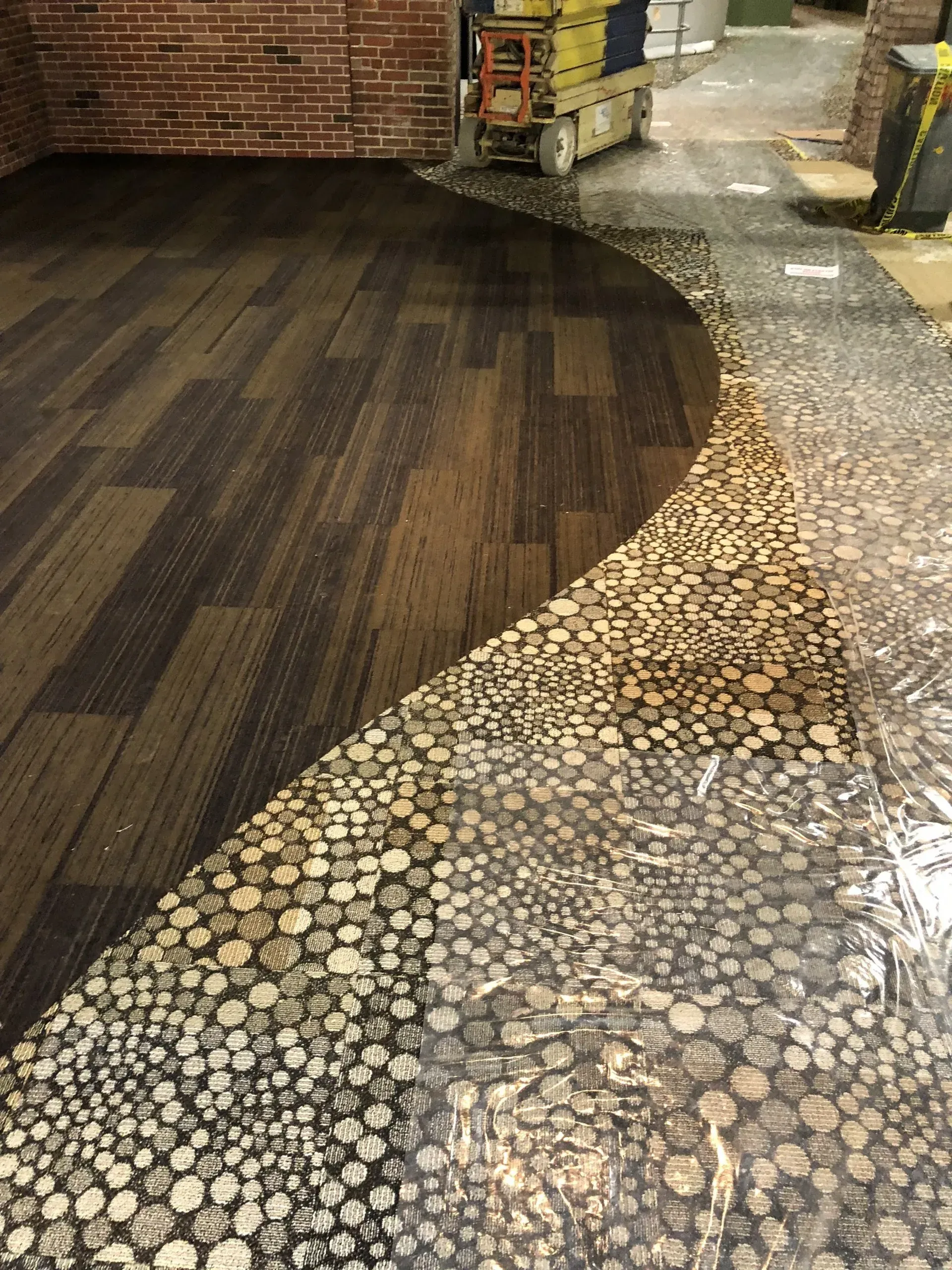 A room with a wooden floor and a brick wall.