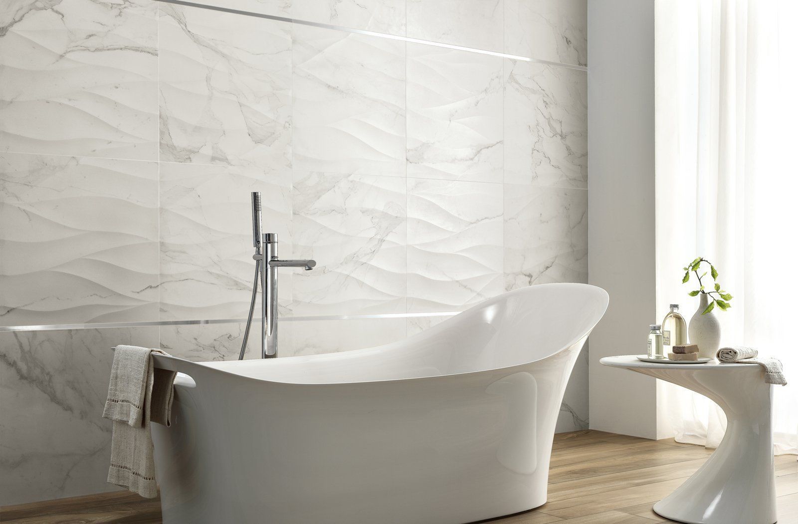There is a bathtub in the bathroom with marble tiles on the wall.