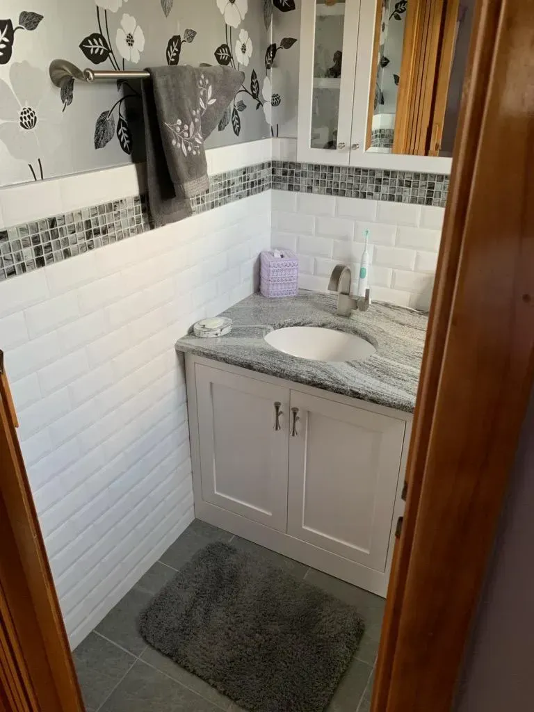 A bathroom with a sink and a rug on the floor