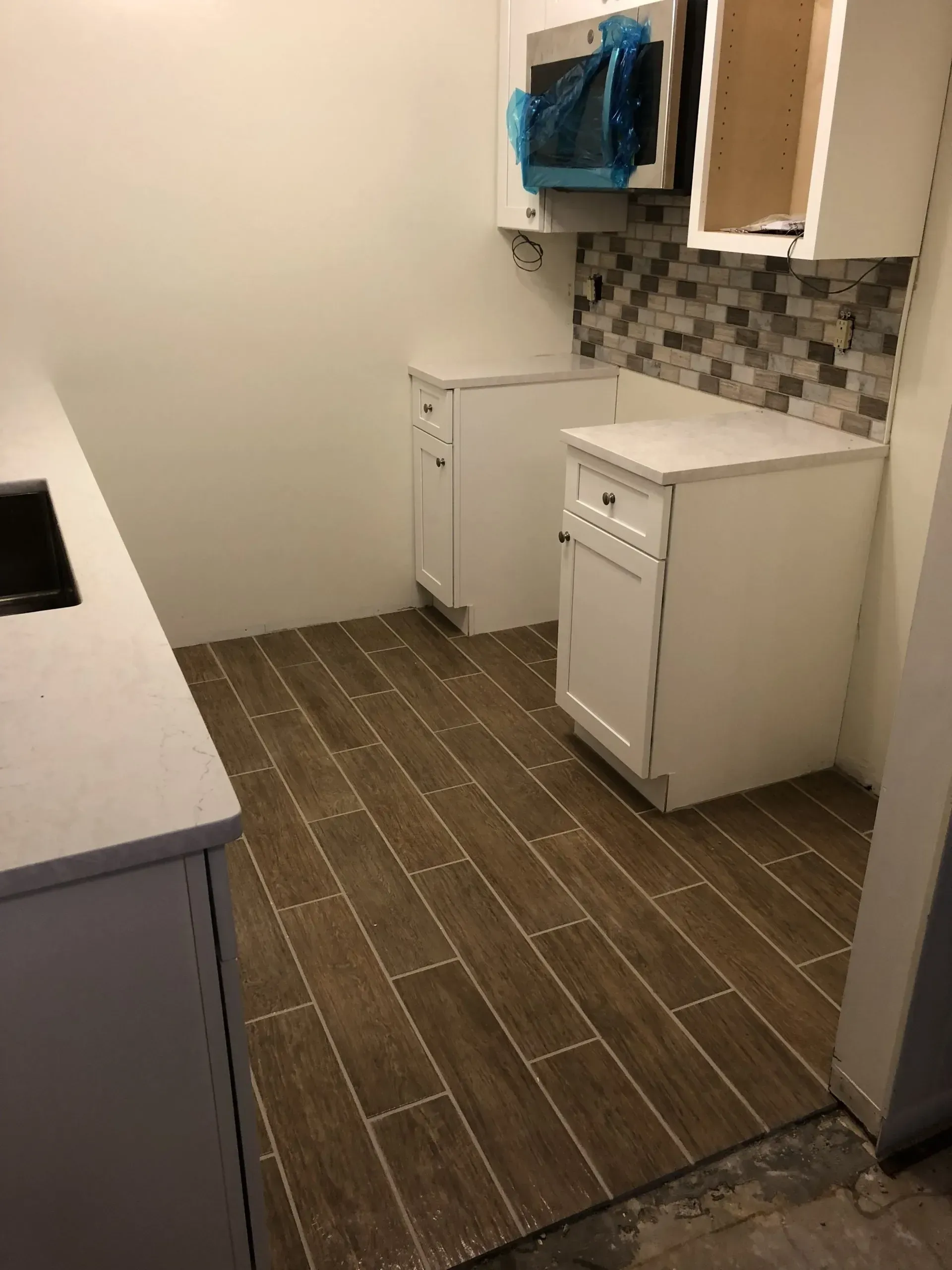A bathroom with a sink , mirror and cabinets.