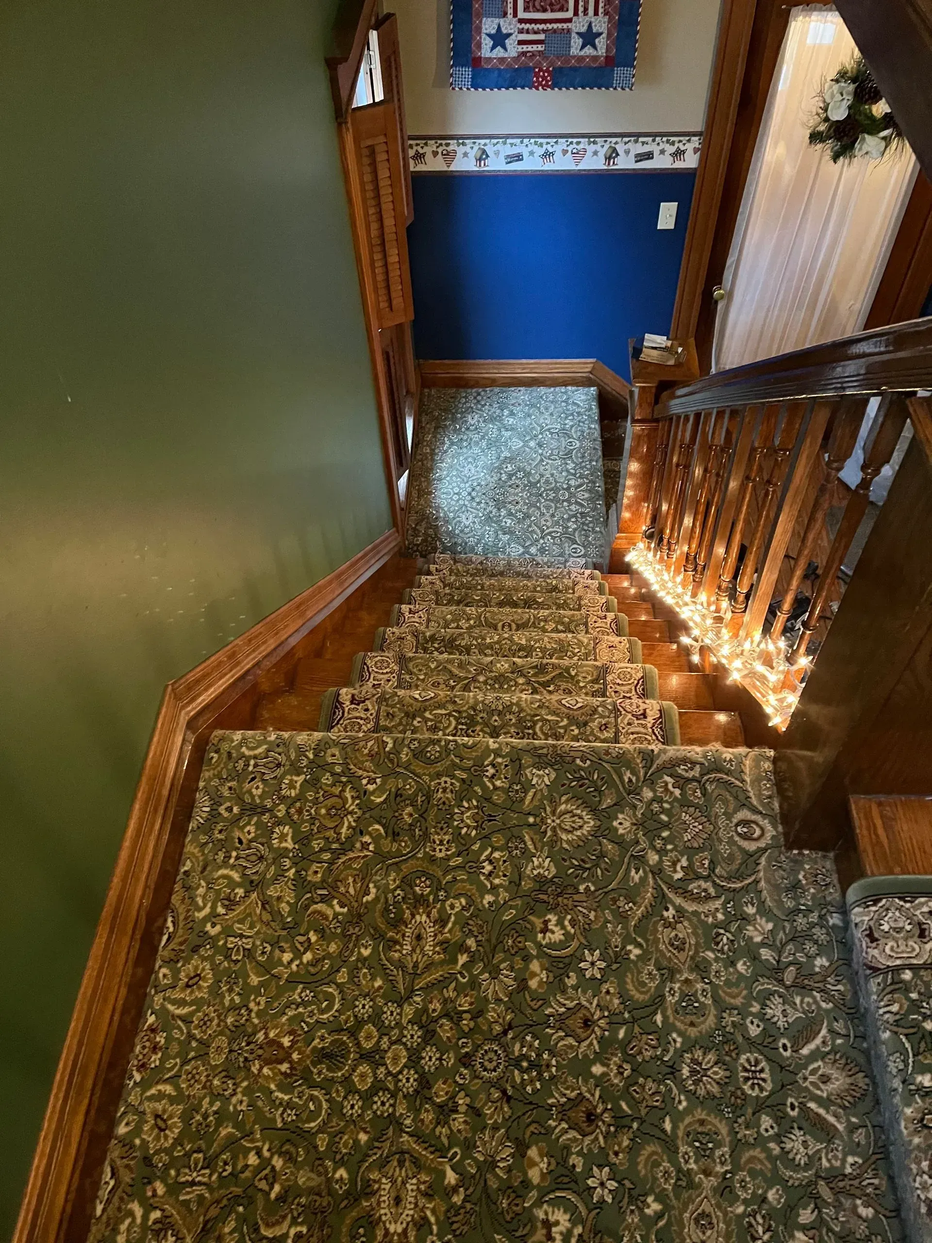 A staircase with a carpet on the floor and a wooden railing.