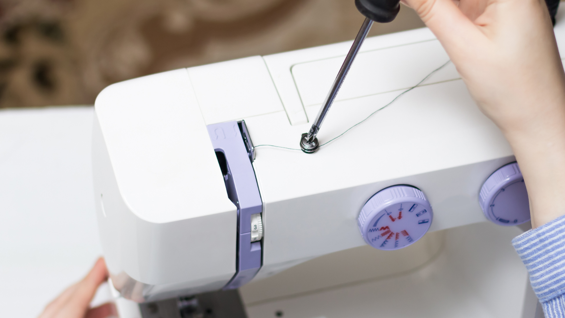 Sewing machine with Christmas-themed fabric on a wooden table.
