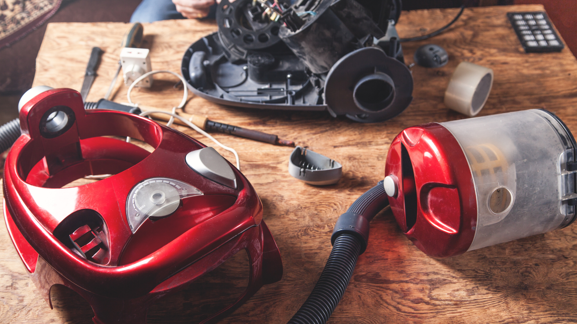 Close-up of a worn, cylindrical brush with a wooden end, metal bearings, and bristles. Held in a hand.