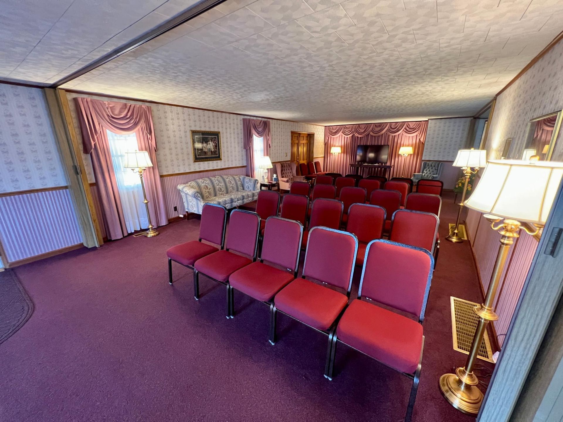 A room with red chairs and a couch in it.