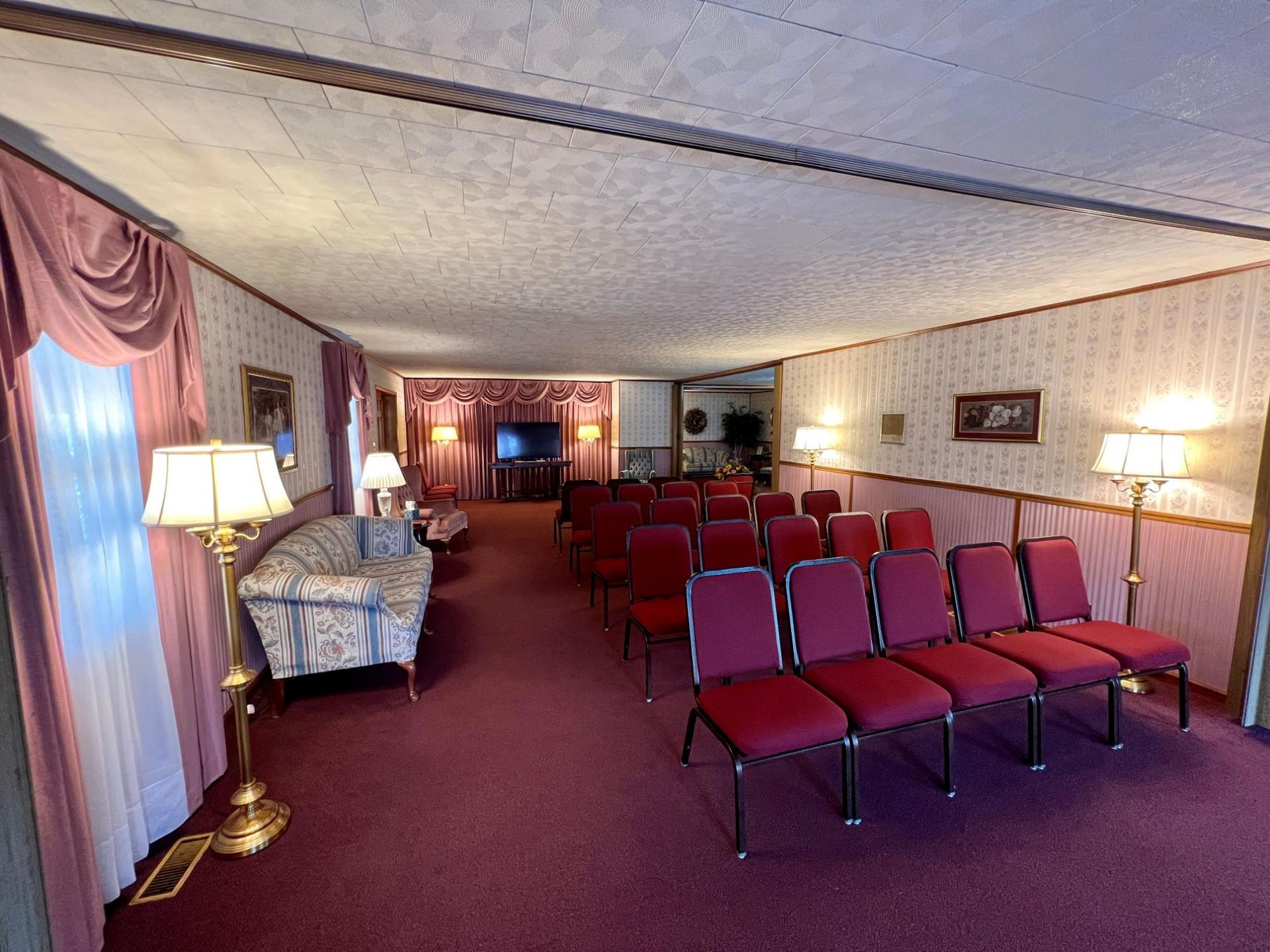 A large room with red chairs and a couch.