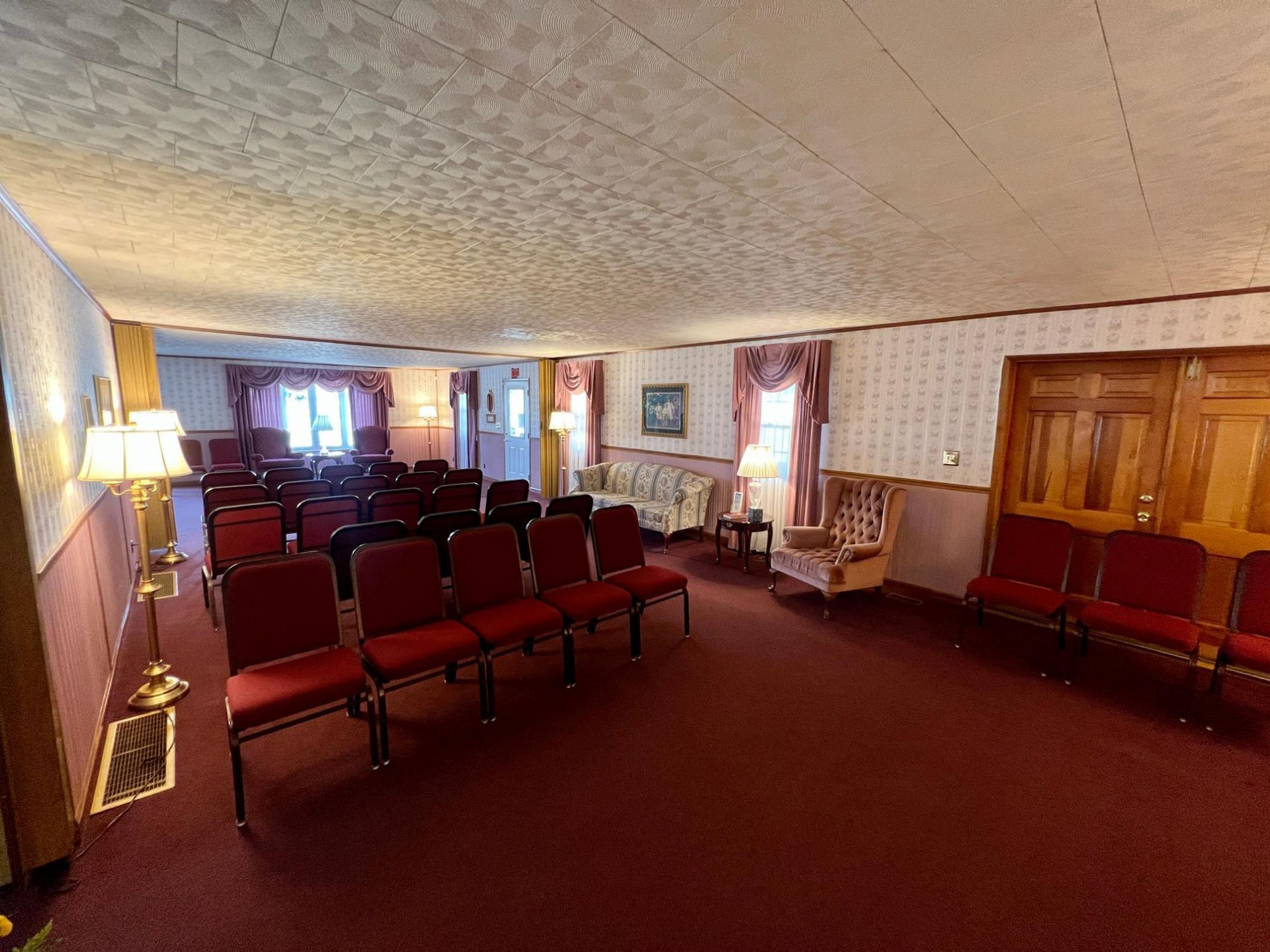 A large room filled with red chairs and a couch.