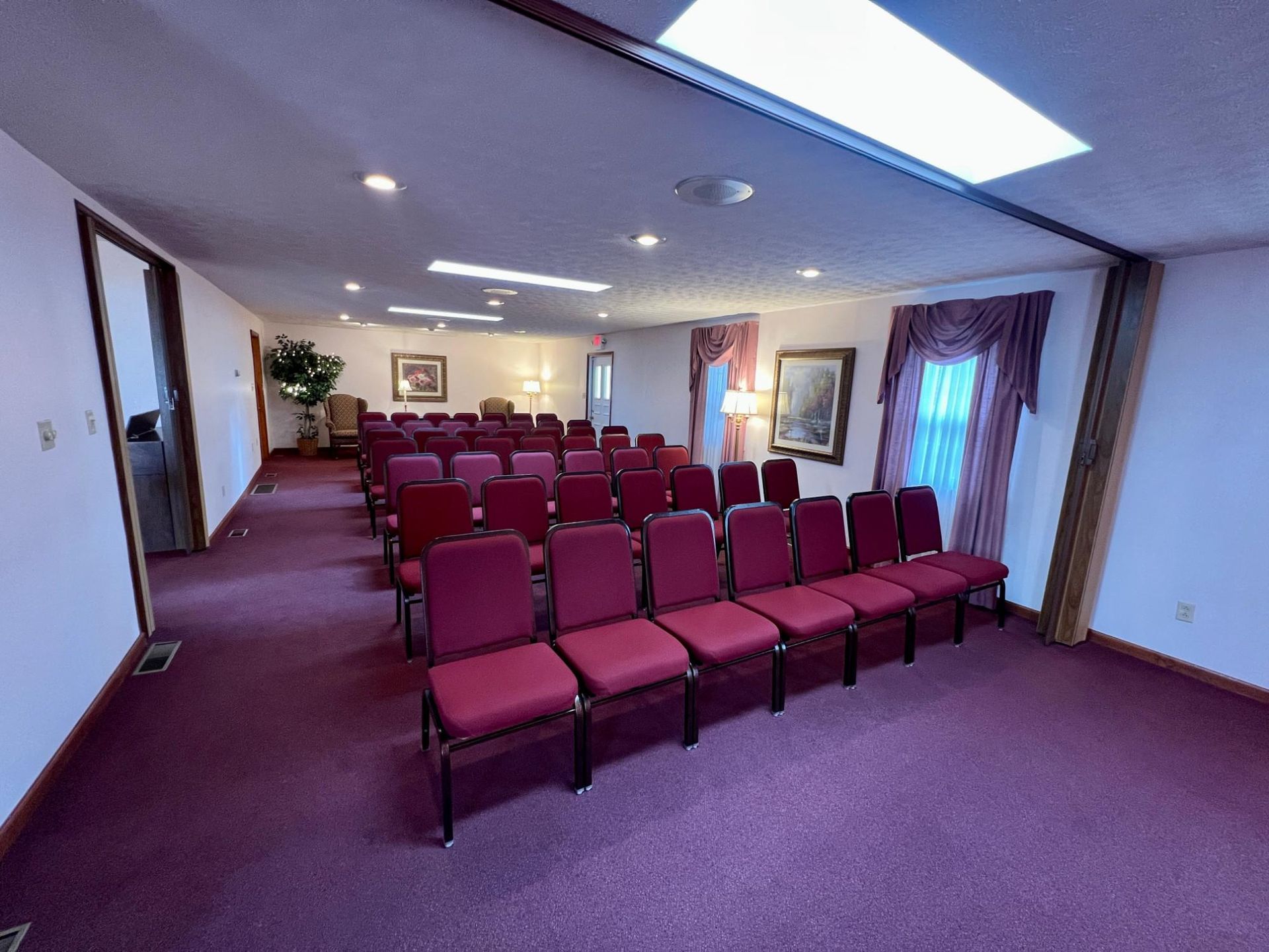 A row of red chairs are lined up in a room.