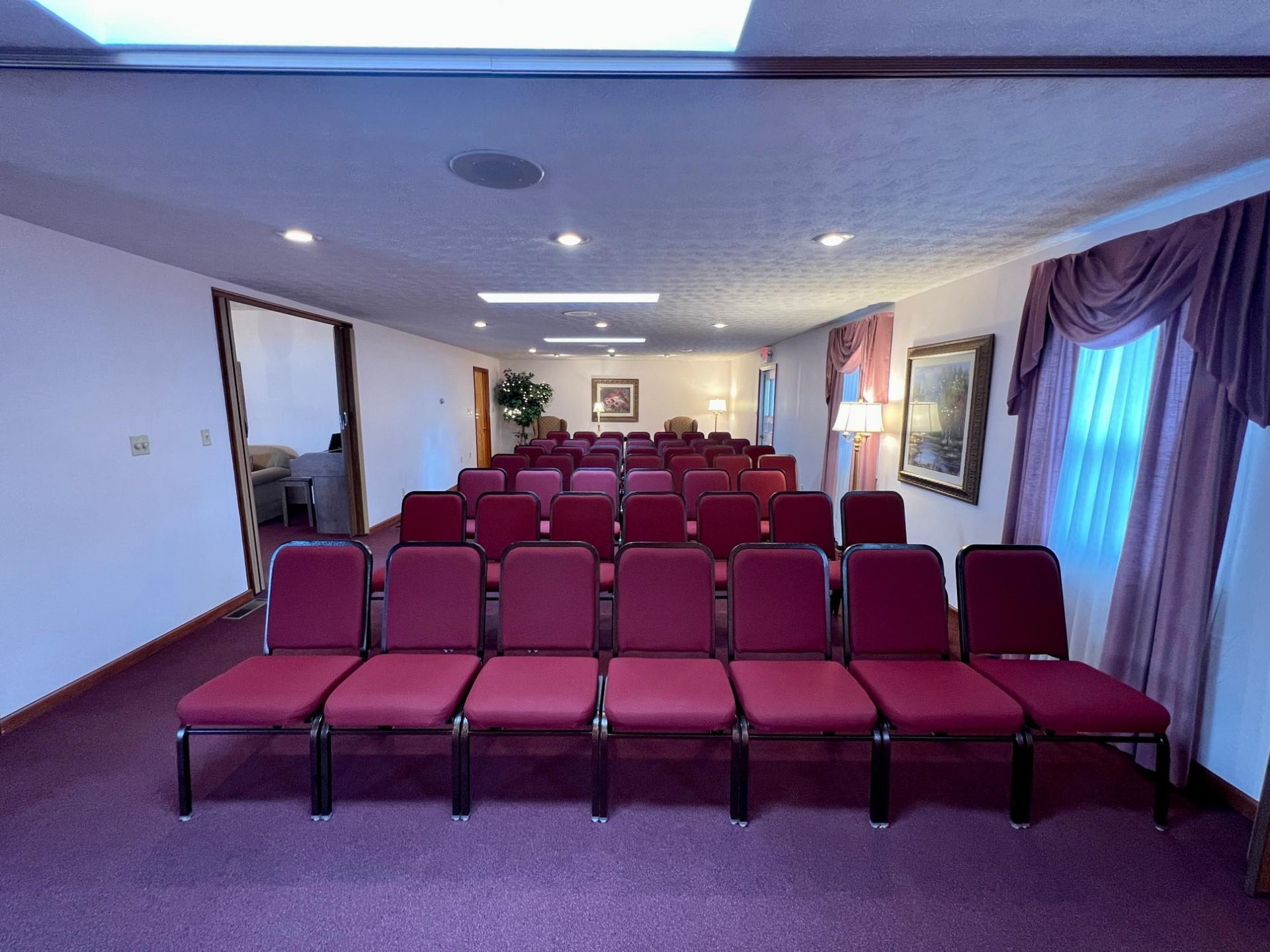 A row of red chairs are lined up in a room.